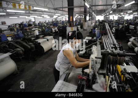 Female worker operating machine at a textile factory in Dongguan, Guangdong, China. 19-Sep-2008 Stock Photo