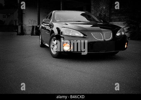 A modern sports sedan with selective color parked in an urban setting Stock Photo