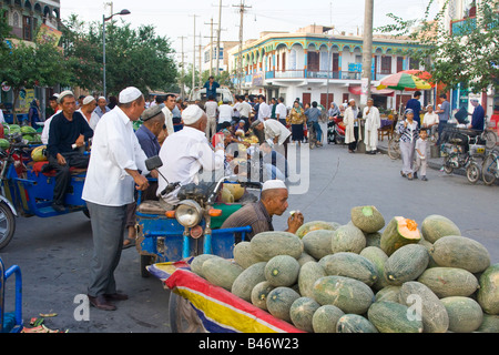 Uygur Men Buying and Selling Melons in Old Kashgar in Xinjiang Province China Stock Photo