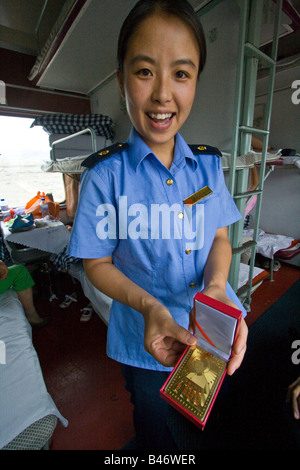 Train Attendant Selling Mao Souvenirs on a Chinese Sleeper Train Stock Photo