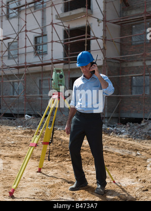 Engineer with theodolite and walkie talkie Stock Photo