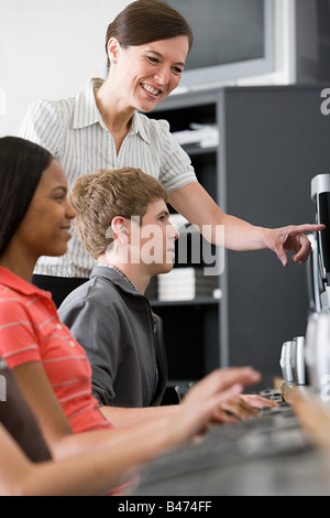 Teacher And Teenage Schoolboy Using Computer In Lab Stock Photo - Alamy