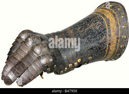 A gauntlet, England, end of the 16th century. Plated finger protection with complete original plates on the original leather. Four times embossed knuckle protectors, the protection for the back of the hand sliding on five lames. Heavy cuff with turned under edge, rising to a point. The inside of the wrist with one sliding lame. Black finish with gold decoration over visible remnants of older, finer gold finish. The original leather glove with clear marks of age is sewn in. Length 33 cm. High quality gauntlet in undisturbed original condition. historic, historic, Stock Photo