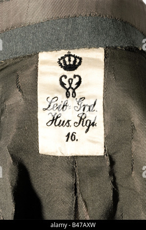 Kaiser Wilhelm II, an interim field grey attila for the Hussar Life Guards Regiment Fine, field grey cloth, with cord fastenings of interwoven flat cords of silver and black (unevenly darkened), golden rosettes and toggle. Field grey silk lining (several rips due to age). Label with an embroidered, crowned 'W' and 'Leib-Grd. Hus. Rgt. 16'. Sleeved epaulets with silver marshall's batons and golden ciphers. Sewn-on neck cloth with the order ribbon of the Pour le mérite with oak leaves. Order loops and a fabric cross for the Order of St. John. The left sleeve of t, Stock Photo
