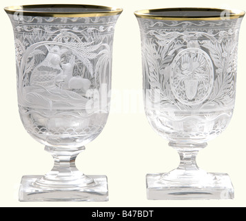 Hermann Göring, two goblets from a hunter's table service Cut and faceted crystal glass with gold rims. On the viewing side an oriental prince lying in a palm grove and holding a roe deer fawn in his arms. The Göring family arms surmounted by a helmet are set in a medallion on the reverse side. Rich floral decoration. Six-sided stems on square feet. Height 13 cm. One glass with a tiny chip in the rim. Provenance: Voluntary auction from the former possessions of Hermann Göring, Neumeister, formerly Weinmüller, 157th Auction, 25 October 1974, lots 3051 to 3058. P, Stock Photo