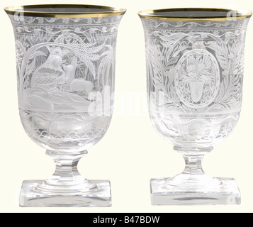Hermann Göring, two goblets from a hunter's table service Cut and faceted crystal glass with gold rims. On the viewing side an oriental prince lying in a palm grove and holding a roe deer fawn in his arms. The Göring family arms surmounted by a helmet are set in a medallion on the reverse side. Rich floral decoration. Six-sided stems on square feet. Height 13 cm. Provenance: Voluntary auction from the former possessions of Hermann Göring, Neumeister, formerly Weinmüller, 157th Auction, 25 October 1974, lots 3051 to 3058. Presumably a gift for Göring's 50th Birt, Stock Photo