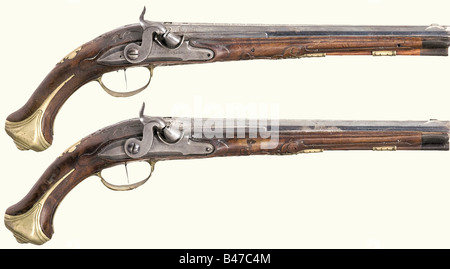 A pair of percussion pistols, Johann Andreas Kuchenreuter, Steinweg bei Regensburg, circa 1780. Blued, smooth bore barrels in 12 mm calibre. Silver front sights and a silver-inlaid signature on the sighting flats. There are four silver-filled marks between inlaid scroll decorations on each of the breeches. The tangs are inscribed '1' and '2'. Converted locks with engraved signature. Set triggers. Lightly carved walnut fullstocks. Blank brass escutcheons with the monogram 'AM' stamped above them. Smooth brass furniture. Original wooden ramrods with horn tips. Le, Stock Photo