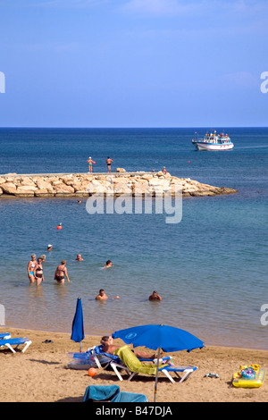 VIEW OF PERNERA BEACH NEAR PARALIMNI, PROTARAS, IN CYPRUS WITH BLUE UMBRELLAS AND GOLDEN SAND Stock Photo