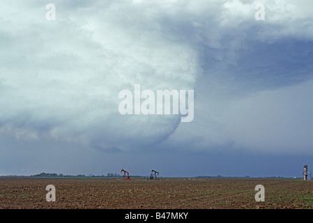 Severe thunderstorm over a field and oil wells near Perry Oklahoma Stock Photo
