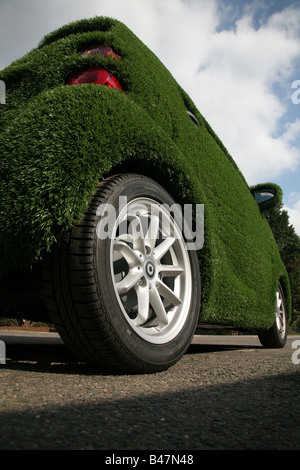 Smart car covered in artificial grass in street London UK Stock Photo