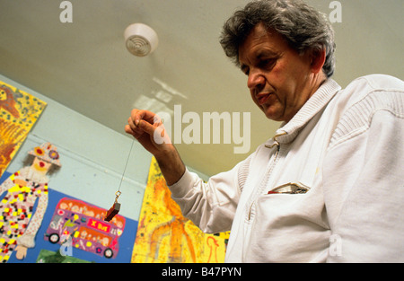 A primary school teacher explaining the priciples of magnetism to his class. Stock Photo