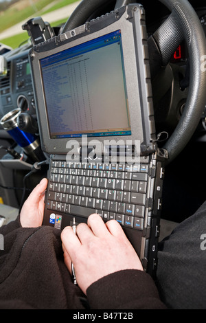 Mobile engineer using small rugged laptop computer in his van cabin to check his itinerary with his office to keep in touch Stock Photo