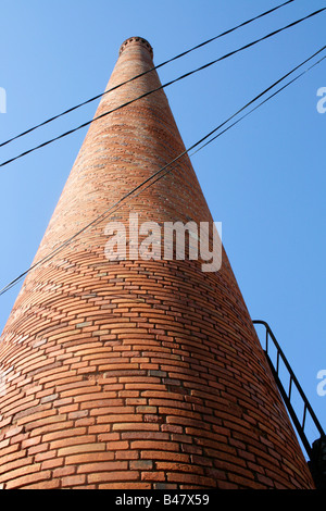 tall round brick industrial chimney with pattern in brickwork made from curved bricks. Cenne-Monesties Languedoc Southern France Stock Photo