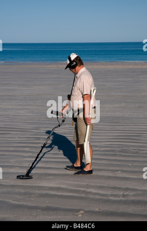 Man with metal detector and spade looking for lost objects on Cable Beache near Broome Western Australia Stock Photo
