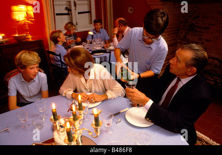 Boy pours water for a teacher during the evening meal Stock Photo