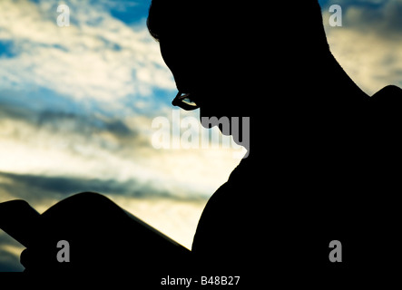 Silhouette of man reading Stock Photo