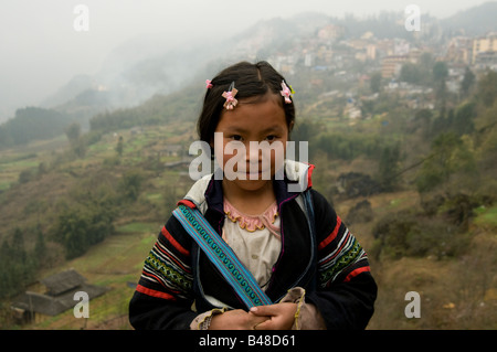 A portrait of an innocent little  Black Hmong girl wearing traditional hmong costume in the hills of Sapa Vietnam Stock Photo