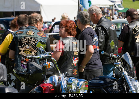 Members of a Harley Davidson Owners Group chat amongst their bikes Stock Photo