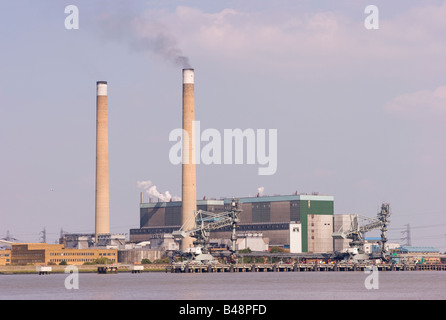 Black smoke being emitted from one of a pair of chimneys of the Barking coal fired power station on the banks of the River Thames in Essex. Stock Photo