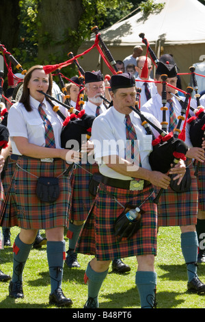 Members of the Milton Keynes Pipe Band march and play the bagpipes Stock Photo