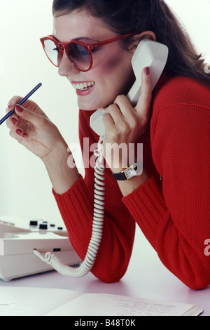 Young executive woman, talking on phone, at desk, in office Stock Photo