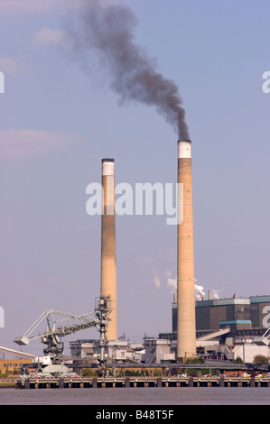 Black smoke being emitted from one of a pair of chimneys of the Barking coal fired power station on the banks of the River Thames in Essex. Stock Photo