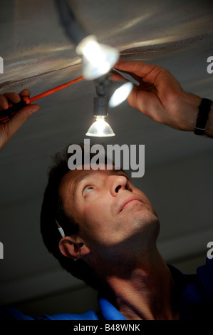 An electrician working on 12 volt light tracking. Picture by Jim Holden. Stock Photo