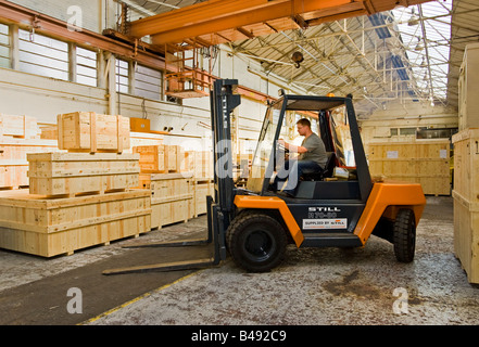 Warehouse - Man driving forklift truck, UK Stock Photo