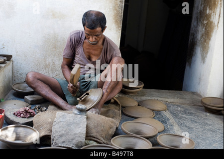 Traditional village Indian potter molding clay lids for earthenware pots. Puttaparthi, Andhra Pradesh, India Stock Photo