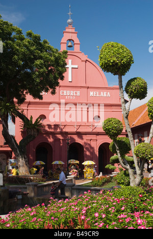 Trishaws parked under the red Christ Church in the popular tourist centre of Dutch Square, Malacca, Malaysia Stock Photo