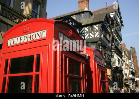 City of Chester, England. Red telephone boxes with Chester’s black and white timbered Tudor style architecture in the background Stock Photo