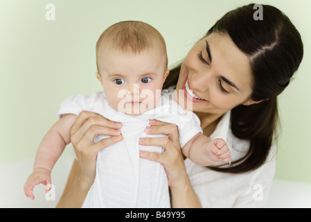 Mother holding baby, smiling Stock Photo