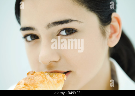 Young woman eating croissant, close-up Stock Photo