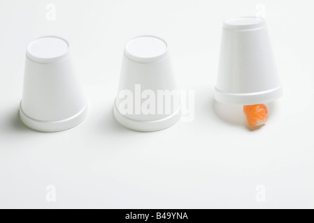 Three disposable cups in row, end cup lifted revealing single piece of nigiri sushi Stock Photo