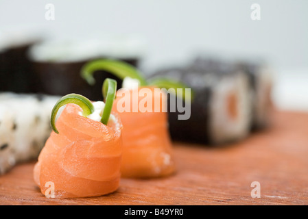 Cropped view of assorted maki sushi, focus on salmon in foreground Stock Photo