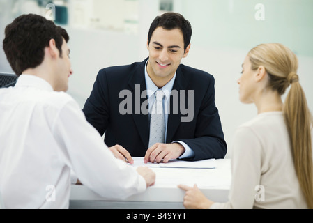 Meeting between professional and clients, together reviewing document Stock Photo