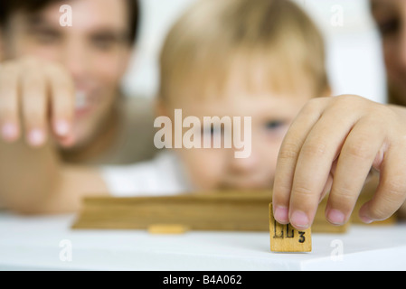 Little boy holding game piece, focus on foreground Stock Photo