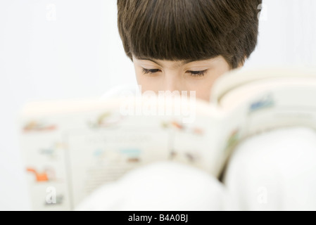 Boy reading book, close-up Stock Photo