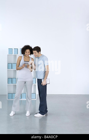 Man and woman looking at DVD together, smiling Stock Photo