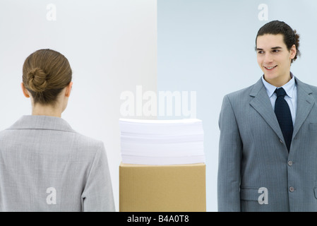 Young business associates walking pass each other in office Stock Photo