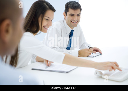 Professionals sitting at table, making conference call Stock Photo
