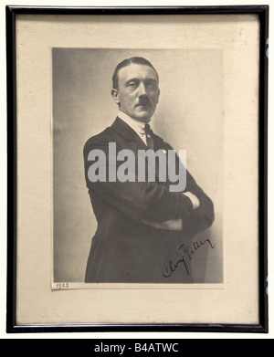 Adolf Hitler - a very early ink autograph, on a portait photograph. Large size photo (16 x 23 cm) by Hoffmann of Hitler in a dark suit with party badge, taken during a photo session in September 1923. 'Adolf Hitler' signed in ink on the lower right, dated '1923' on the left. With mount, framed and under glass. The initials unusual, but undoubtedly original. In a politically very critical stage Hitler developed his autograph from a slightly clumsy type orientated on cursive handwriting to the characteristic signature known from the mid-1920s onwards. Present to , Stock Photo