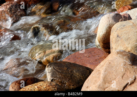 Water flowing over rocks in stream Stock Photo