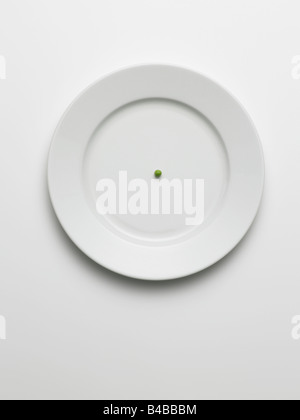 one pea on white plate Stock Photo