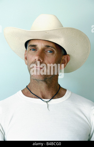Studio Portrait of an Shaven Baby Boomer Aged Man in a Cowboy Hat and Thermal White Undershirt Stock Photo