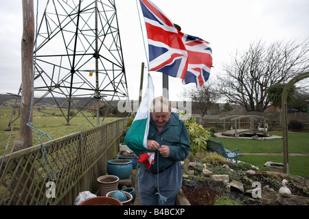 Patriotic pensioner Ivor Dowling attaches the Welsh flag beneath the Union Jack to fly in his back Somerset garden Stock Photo
