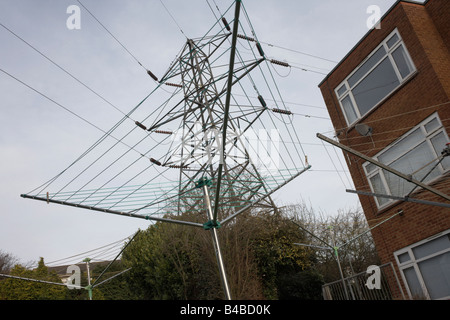 A clothes line merges with the lines of an L6 electricity pylon near flats on the Hales Place estate in Canterbury Stock Photo