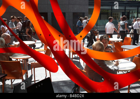Office workers mingle and chat in warm late-summer sunshine during a lunchtime break on London's southbank, near Tower Bridge Stock Photo