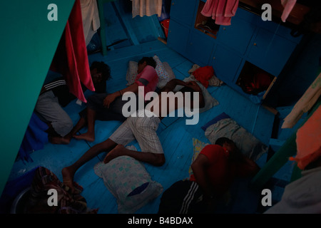 A Maldivian crew rest before a day's yellowfin tuna fishing aboard a traditional dhoni fishing boat on the Indian Ocean Stock Photo