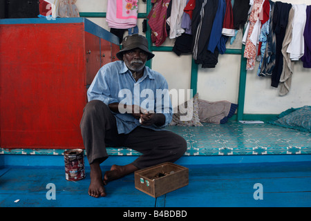 A Maldivian crewman cuts betel nut before a day's yellowfin tuna fishing on traditional dhoni fishing boat in the Indian Ocean Stock Photo